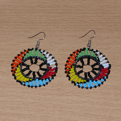 Boucles d'oreilles ethniques rondes à motifs zoulous composées de perles de rocaille noires et multicolores. De taille moyenne et légères à porter, elles mesurent 6 cm de long et 4 cm de large. 