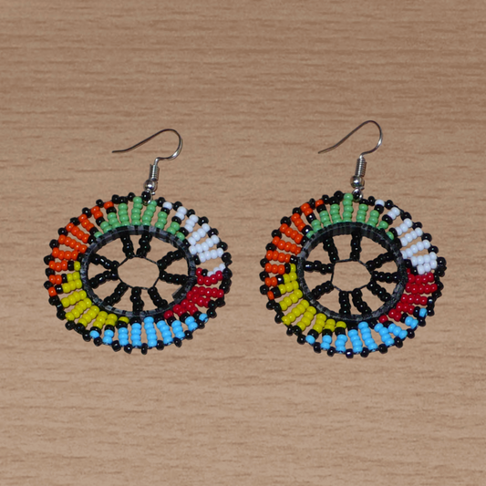 Boucles d'oreilles ethniques rondes à motifs zoulous composées de perles de rocaille noires et multicolores. De taille moyenne et légères à porter, elles mesurent 6 cm de long et 4 cm de large. 