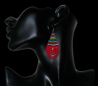Boucles d'oreilles sud-africaines rouges et multicolores composées de perles de rocaille tissées en forme de gouttes. Elles mesurent 7 cm de long et 2,5 cm de large et se portent sur des oreilles percées.
