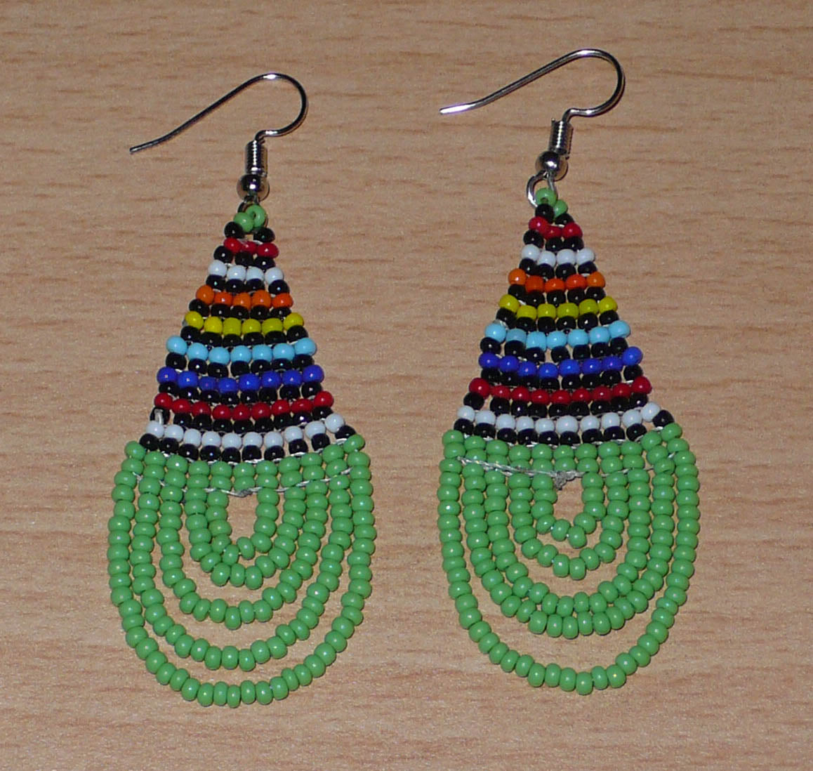 Boucles d'oreilles africaines vertes et multicolores de tradition sud-africaine zouloue composées de perles de rocaille tissées en forme de gouttes. Elles mesurent 7 cm de long et 2.5 cm de large.