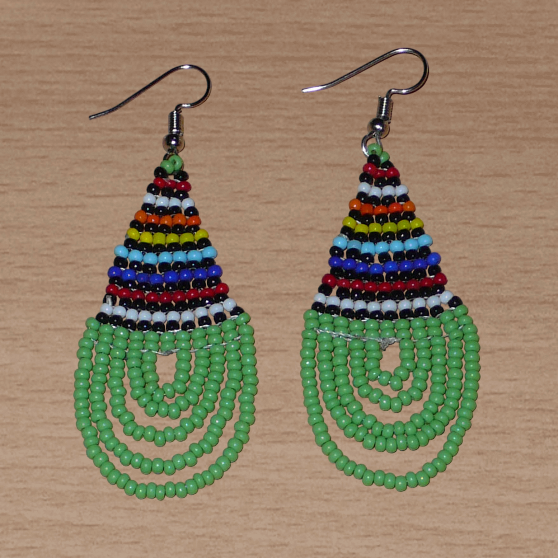 Boucles d'oreilles africaines vertes et multicolores de tradition sud-africaine zouloue composées de perles de rocaille tissées en forme de gouttes. Elles mesurent 7 cm de long et 2.5 cm e large.