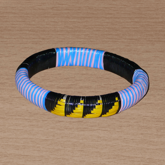 Bracelet africain à motifs ethniques, fabriqué dans une optique écologique, composé d'un tissage de bandes de plastique recyclé noir, jaune, rose et bleu.
