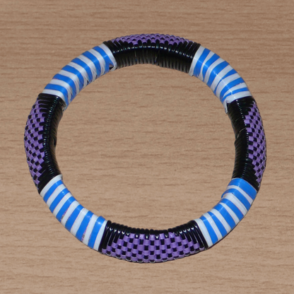 Bracelet africain à motifs ethniques rayés et à damiers composé d'un tissage de fines bandelettes de plastique recyclé violet, bleu, noir et blanc.