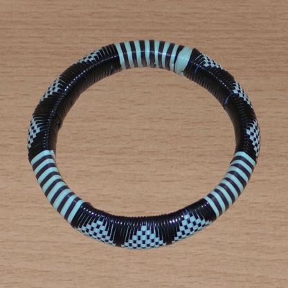 Bracelet africain noir et bleu à motifs ethniques rayés et à damiers, fabriqué au Burkina Faso dans une optique artisanale eco-responsable, composé de fines bandes de plastique recyclé.