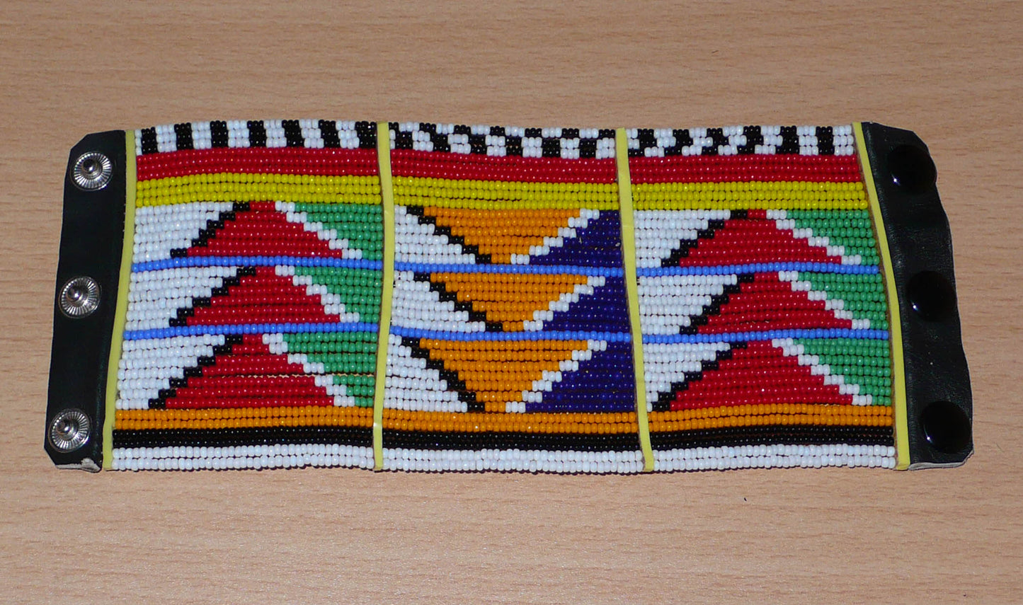 Bracelet africain traditionnel à motifs tribaux Massai composé de perles de rocaille multicolores glissées sur trente-six rangées de fils de fer insérés dans des charnières en plastique, il s'attache avec des boutons pressions.