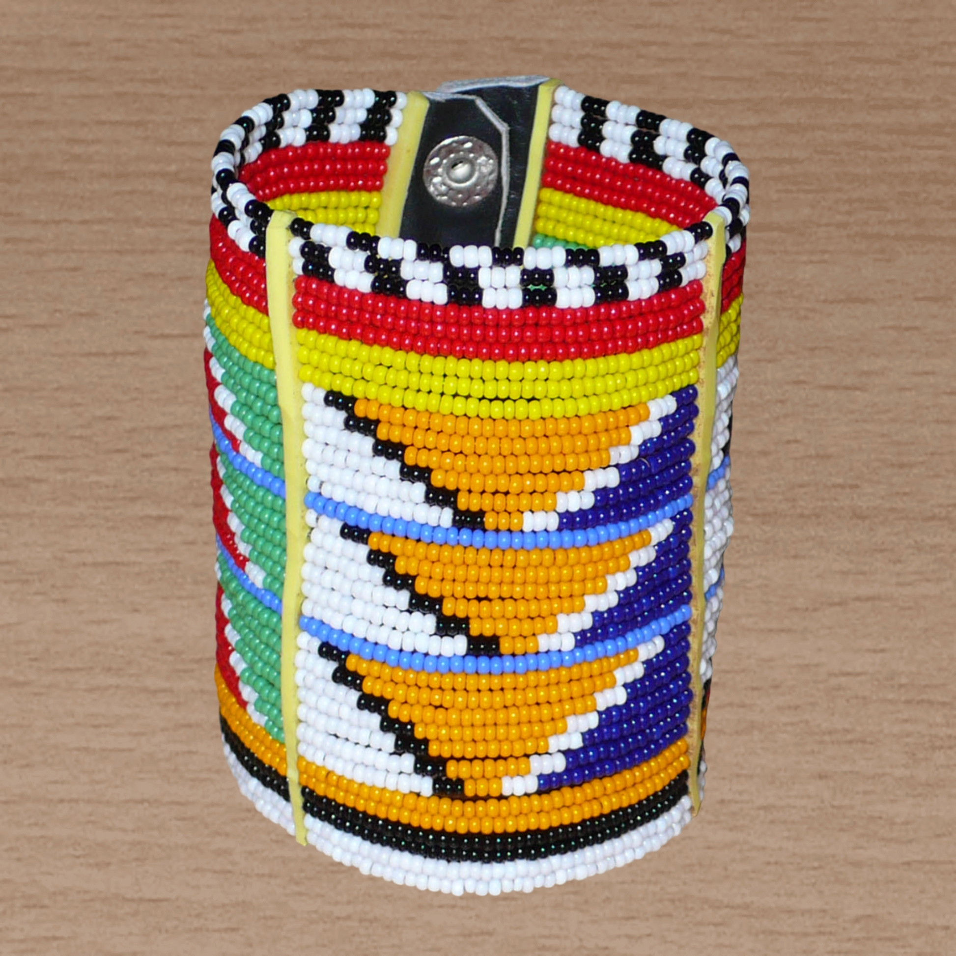 Bracelet africain traditionnel à motifs tribaux Massai composé de perles de rocaille multicolores glissées sur trente-six rangées de fils de fer insérés dans des charnières en plastique, il s'attache avec des boutons pressions.
