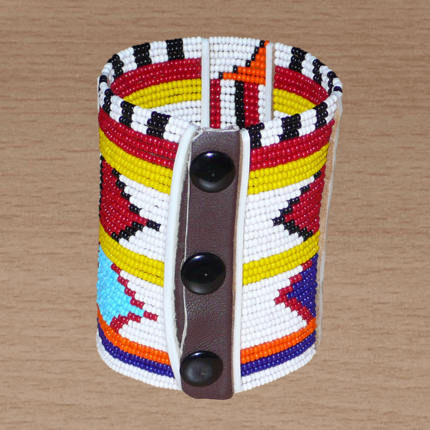 Bracelet africain traditionnel Massai aux couleurs exotiques composé de plusieurs rangées de perles de rocaille blanches et multicolores glissées sur des fils de fer fixés sur des charnières en plastique blanc.