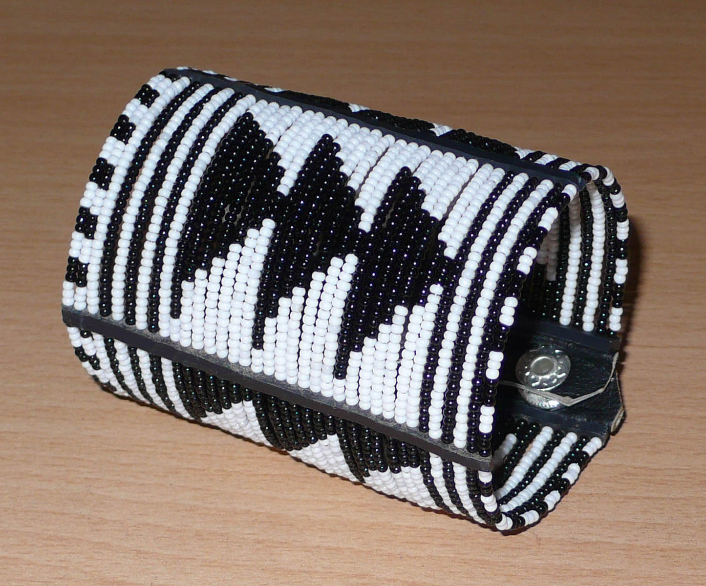 Bracelet africain Massai bicolore à motifs ethniques composé de plusieurs rangées de perles de rocaille noires et blanches.
