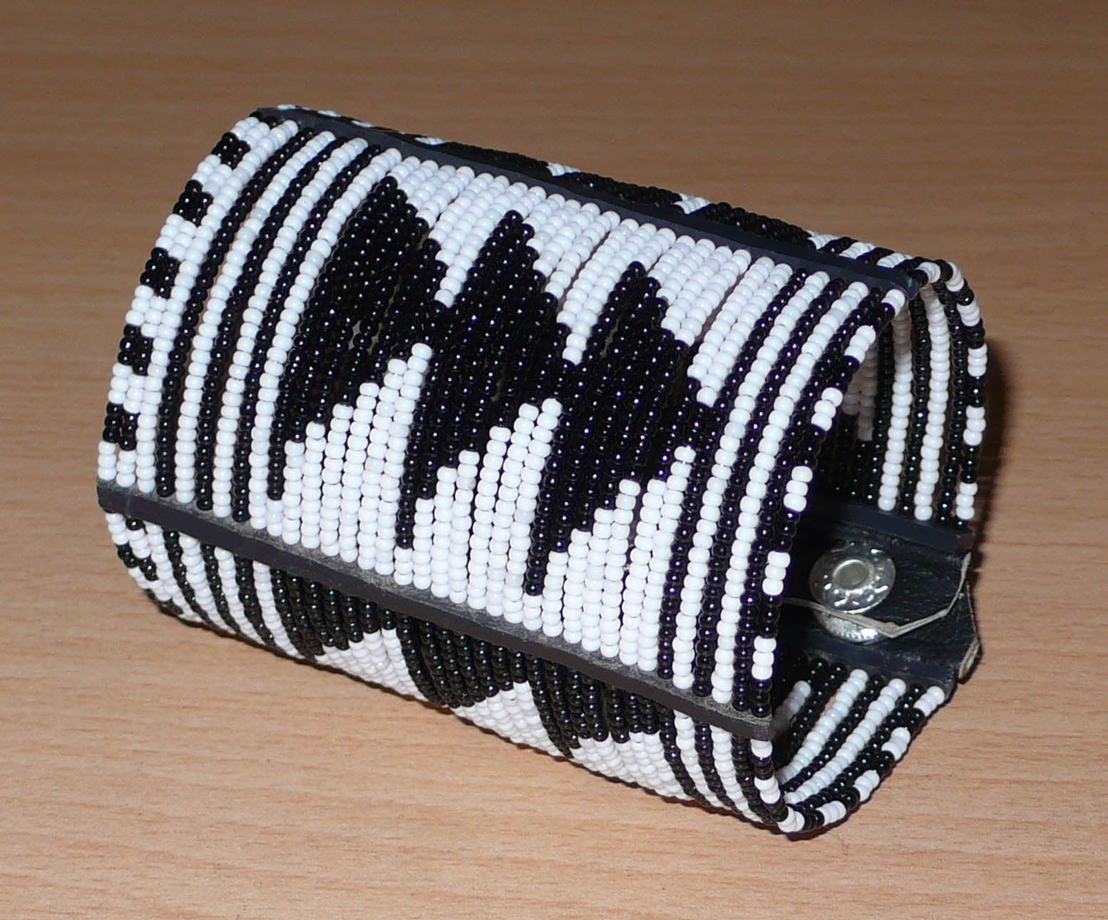 Bracelet africain Massai bicolore à motifs ethniques composé de plusieurs rangées de perles de rocaille noires et blanches.