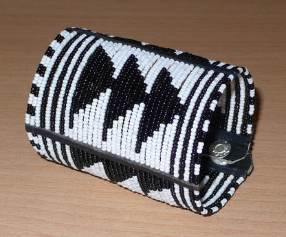 Bracelet africain Massai bicolore à motifs ethniques composé de plusieurs rangées de perles de rocaille noires et blanches.