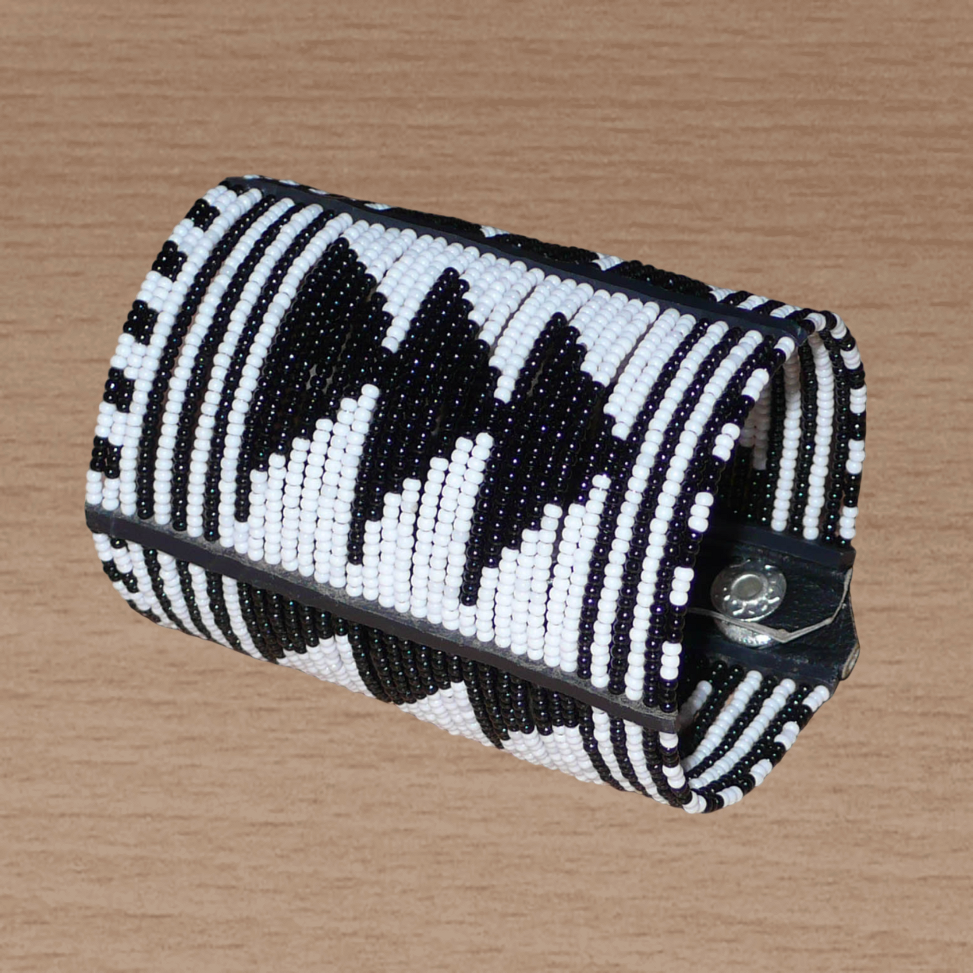 Bracelet africain Massai bicolore à motifs ethniques composé de plusieurs rangées de perles de rocaille noires et blanches.