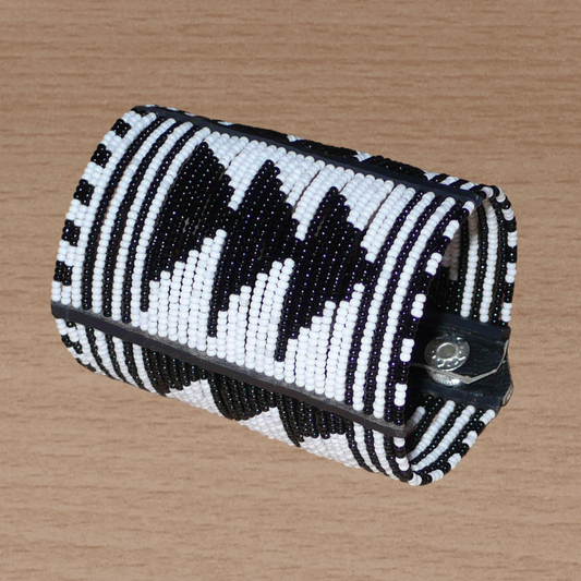 Bracelet africain Massai bicolore à motifs ethniques composé de plusieurs rangées de perles de rocaille noires et blanches.