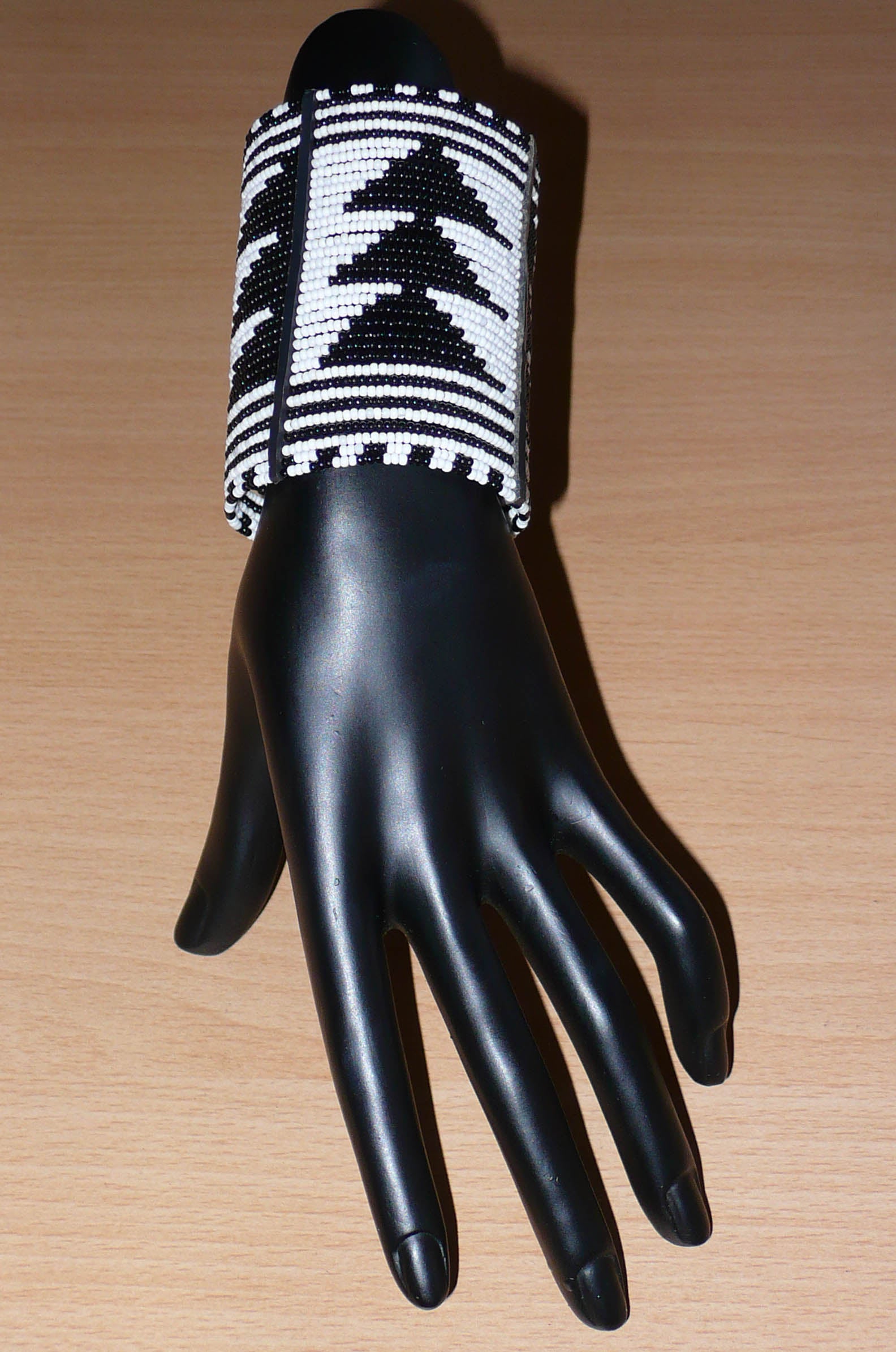 Bracelet africain Massai bicolore à motifs ethniques composé de plusieurs rangées de perles de rocaille noires et blanches.