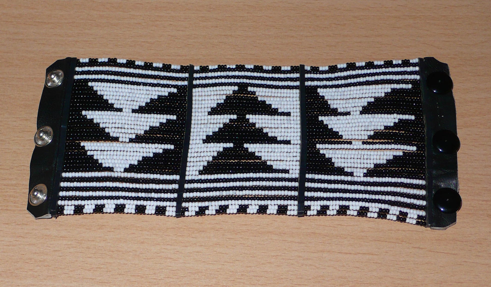 Bracelet africain Massai bicolore à motifs ethniques composé de plusieurs rangées de perles de rocaille noires et blanches.