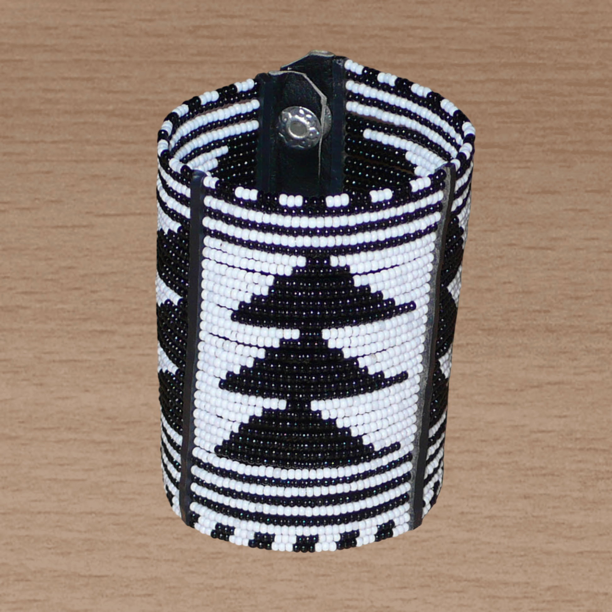 Bracelet africain Massai bicolore à motifs ethniques composé de plusieurs rangées de perles de rocaille noires et blanches.