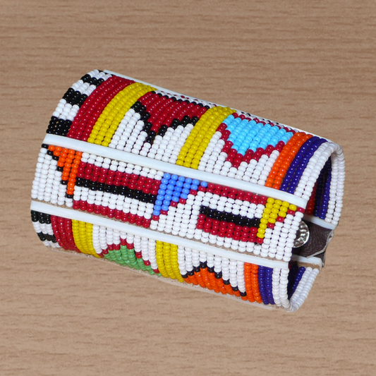 Bracelet africain pour enfant à motifs ethniques traditionnels Massai composé de trente-six rangées de perles de rocaille blanches et multicolores glissées sur des fils de fer fixés sur des charnières en plastique blanc.