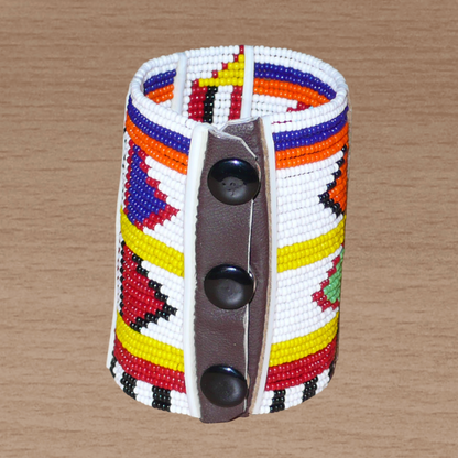 Bracelet africain pour enfant à motifs ethniques traditionnels Massai composé de trente-six rangées de perles de rocaille blanches et multicolores glissées sur des fils de fer fixés sur des charnières en plastique blanc.