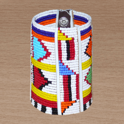 Bracelet africain pour enfant à motifs ethniques traditionnels Massai composé de trente-six rangées de perles de rocaille blanches et multicolores glissées sur des fils de fer fixés sur des charnières en plastique blanc.