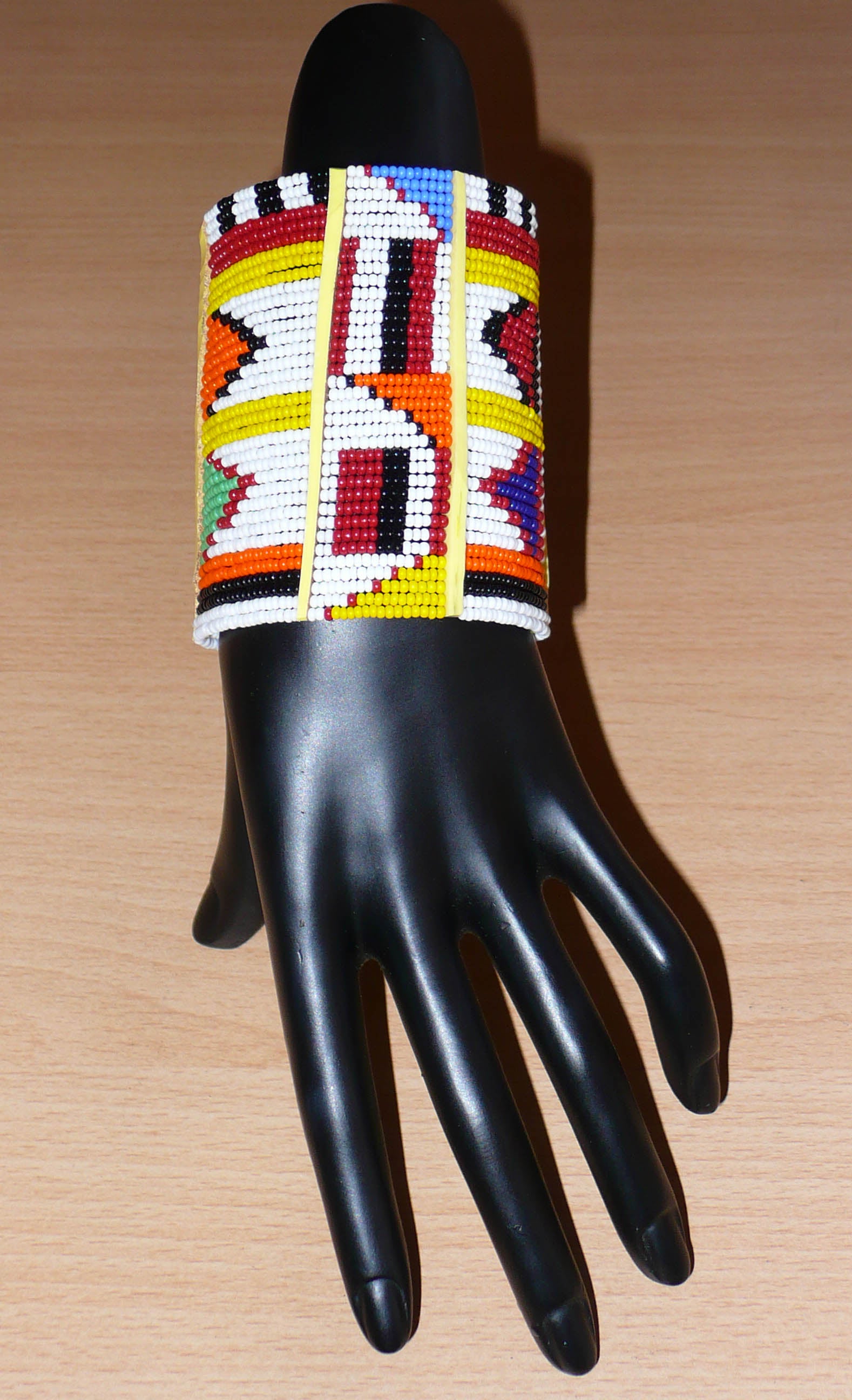 Bracelet africain traditionnel à motifs ethniques Massai composé de perles de rocaille blanches et multicolores fixées sur trente-six rangées de fils de fer.
