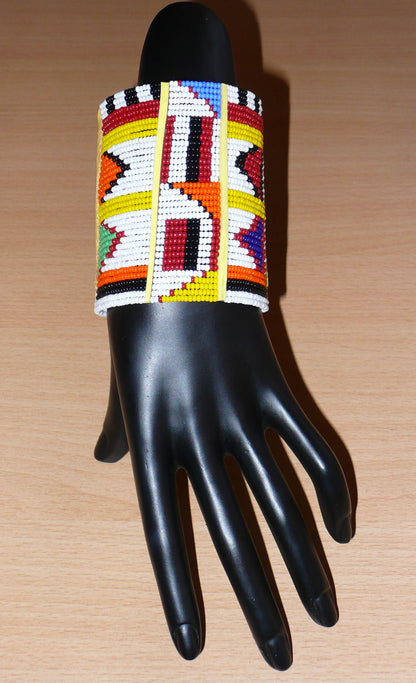 Bracelet africain traditionnel à motifs ethniques Massai composé de perles de rocaille blanches et multicolores fixées sur trente-six rangées de fils de fer.