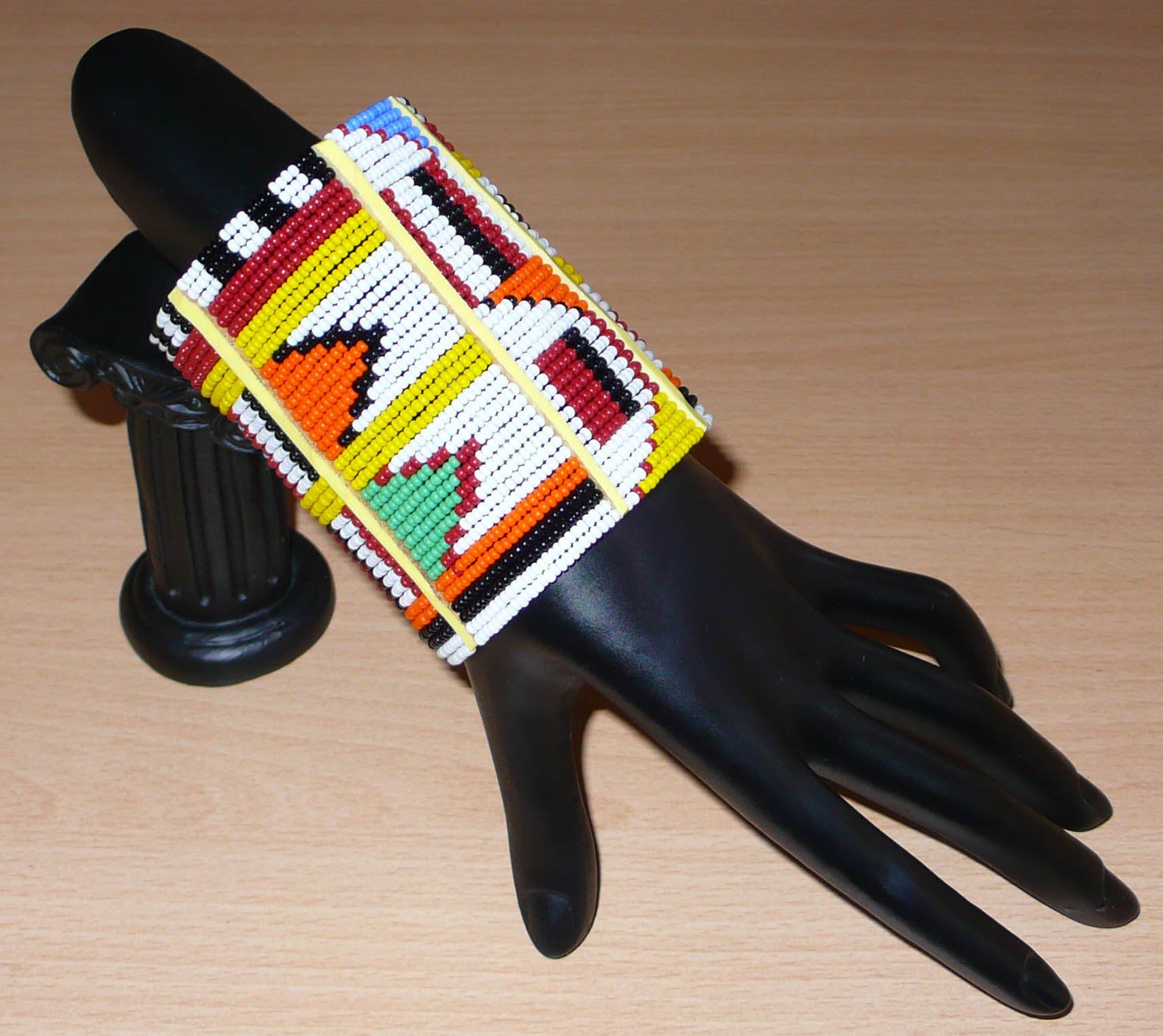 Bracelet africain traditionnel à motifs ethniques Massai composé de perles de rocaille blanches et multicolores fixées sur trente-six rangées de fils de fer.