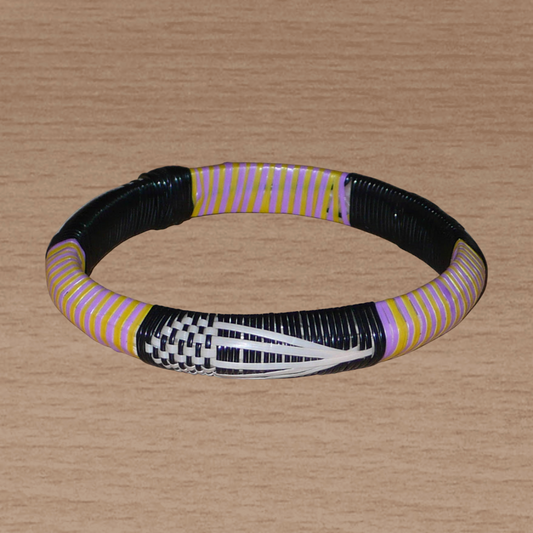 Bracelet africain à motifs ethniques : fabriqué au Mali dans une approche écologique avec des matériaux de récupération, il est tissé avec des bandes de plastique recyclé noir, blanc, jaune et parme.