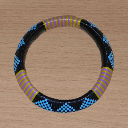 Bracelet africain à motifs tribaux composé de plastique recyclé bleu, noir, violet et jaune.
