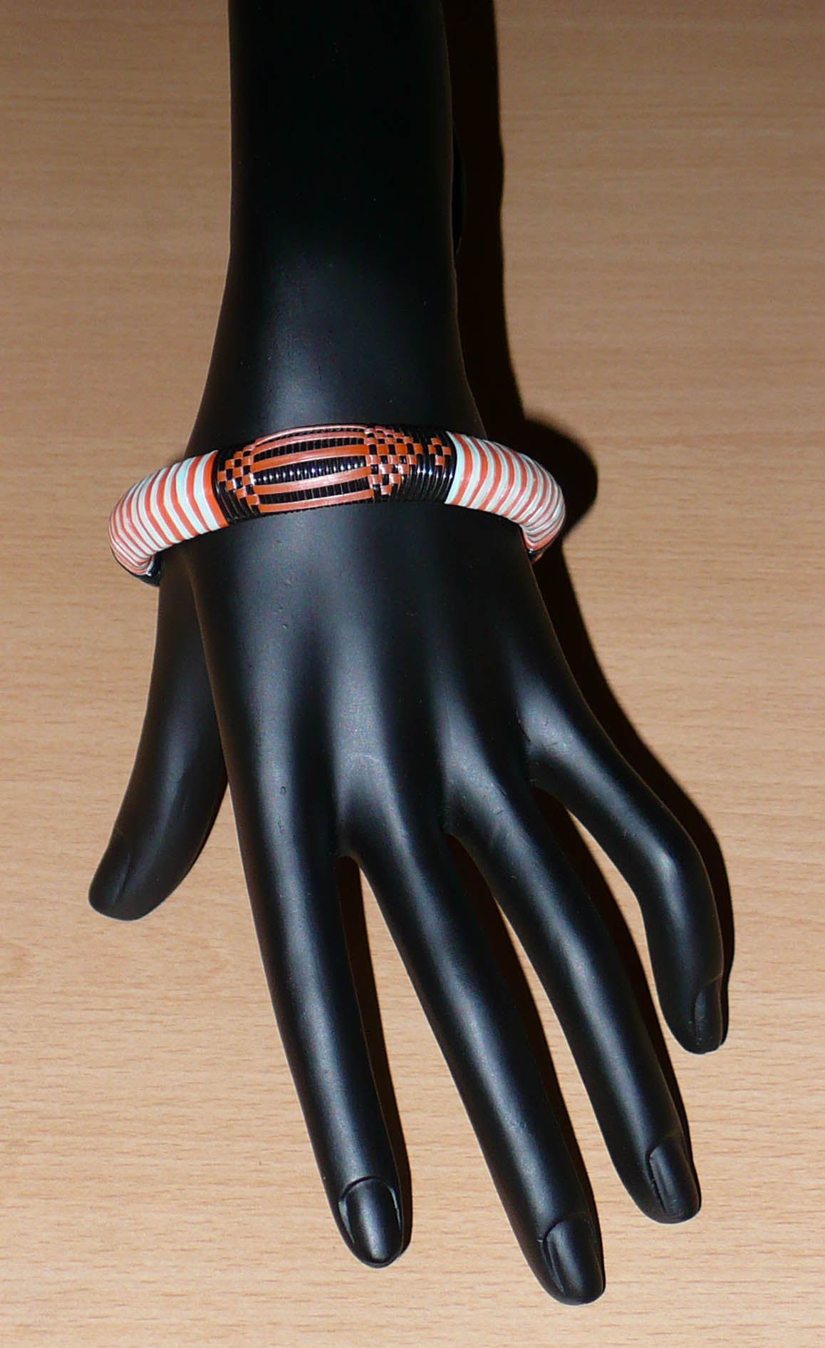 Bracelet africain tribal à motifs ethniques tressés avec du plastique recyclé orange, noir et bleu ciel.