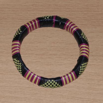 Bracelet africain tricolore à motifs tribaux : fabriqué au Burkina Faso dans une optique artisanale eco-responsable, il se compose de plastique recyclé jaune, noir et violet.