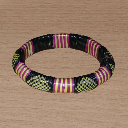 Bracelet africain tricolore à motifs tribaux : fabriqué au Burkina Faso dans une optique artisanale eco-responsable, il se compose de plastique recyclé jaune, noir et violet.