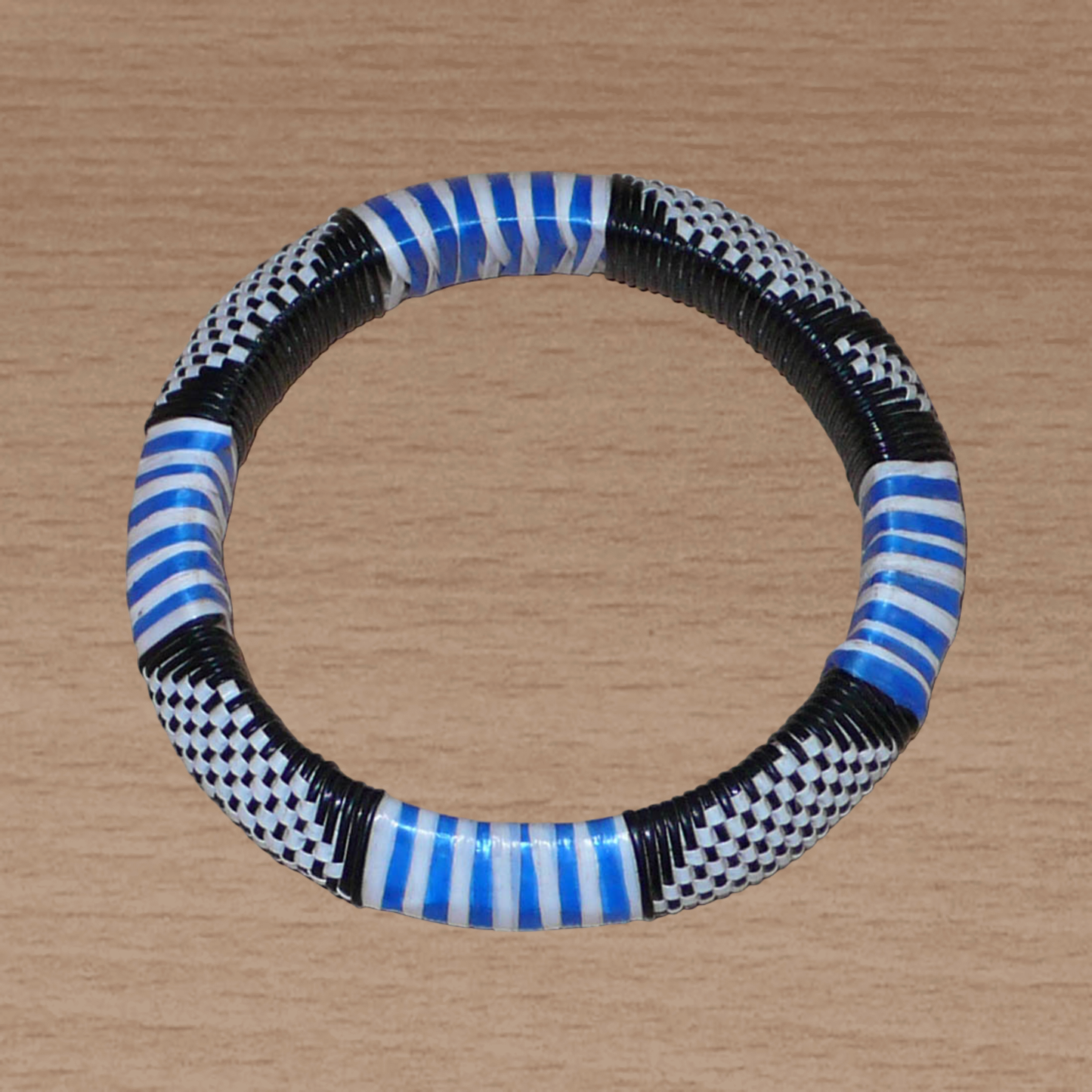 Bracelet africain tricolore à motifs ethniques fabriqué dans une optique eco-responsable avec du plastique recyclé bleu, blanc et noir.