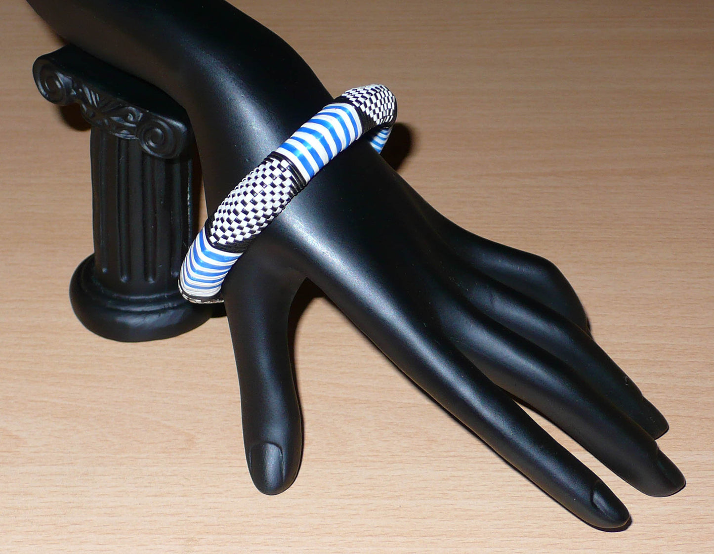 Bracelet africain tricolore à motifs ethniques fabriqué dans une optique eco-responsable avec du plastique recyclé bleu, blanc et noir.