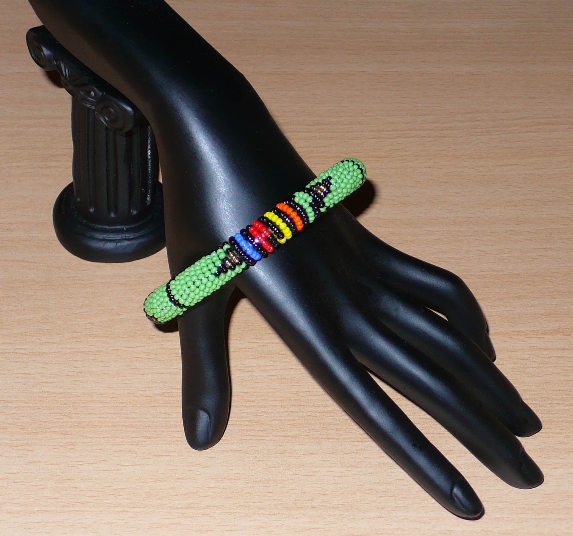 Bracelet sud-africain tubulaire vert et multicolore à motifs ethniques zoulous.