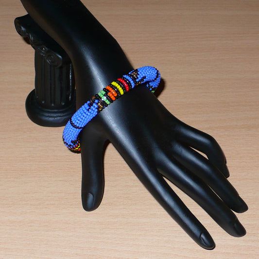 Bracelet africain tubulaire à motifs ethniques traditionnels zoulous composé de perles de rocaille bleues et multicolores.