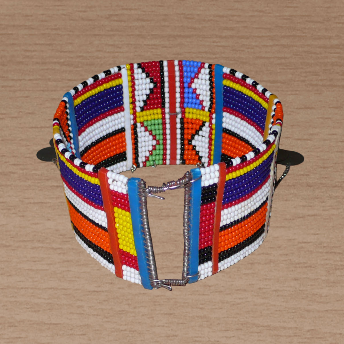 Bracelet de cheville africain Massai à motifs tribaux traditionnels composé de vingt rangées de perles multicolores et décoré de chaînettes et de disques métalliques.