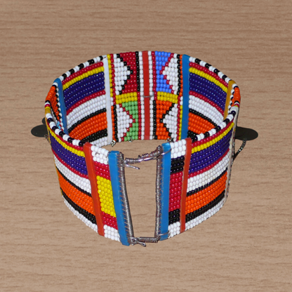 Bracelet de cheville africain Massai à motifs tribaux traditionnels composé de vingt rangées de perles multicolores et décoré de chaînettes et de disques métalliques.