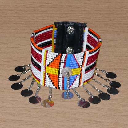Bracelet de cheville africain Massai à motifs géométriques traditionnel composé de dix-sept rangées de perles de rocaille multicolores et prolongé de chaînettes ornées de disques de métal.