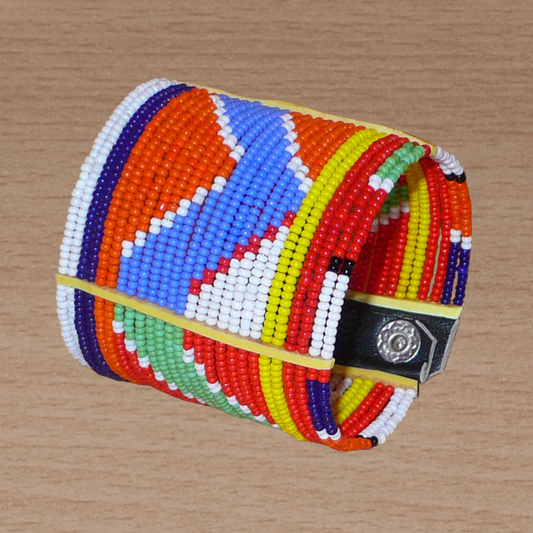 Bracelet africain traditionnel composé de vingt-six rangées de perles multicolores aux couleurs et motifs Massai enfilées sur des fils de fer fixés sur des charnières en plastique. Le bracelet se ferme avec des boutons pressions.