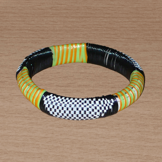 Bracelet africain à motifs ethniques fabriqué dans une démarche eco-responsable ; il est tissé à partir de fines bandes de plastique recyclé noir, blanc, vert et orange.