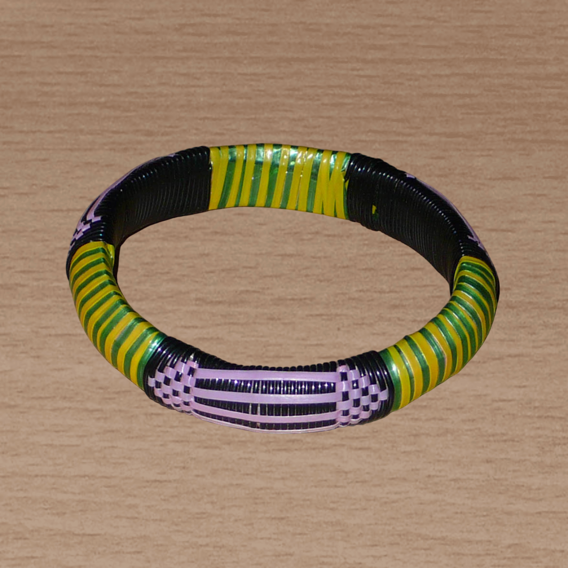 Bracelet africain écolo à motifs ethniques tissés avec des bandes de plastique recyclé noir, violet, vert et jaune.