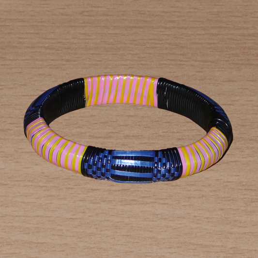 Bracelet africain eco-friendly fabriqué au Mali à motifs ethniques tressés avec des bandes de plastique recyclé noir, bleu, rose et jaune.