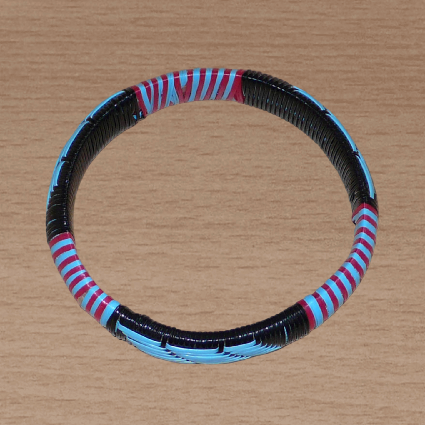 Bracelet africain tricolore à motifs tribaux tissés à partir de plastique recyclé bleu, noir et rose.