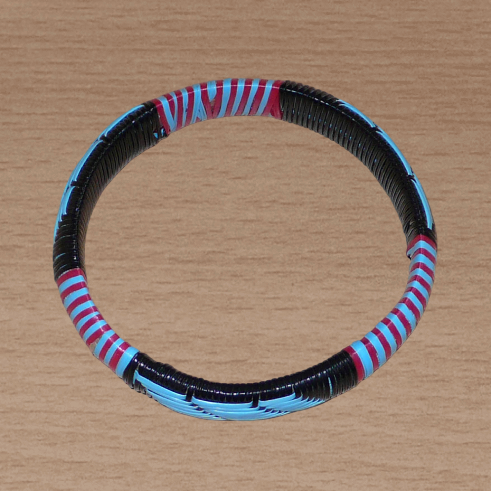 Bracelet africain tricolore à motifs tribaux tissés à partir de plastique recyclé bleu, noir et rose.