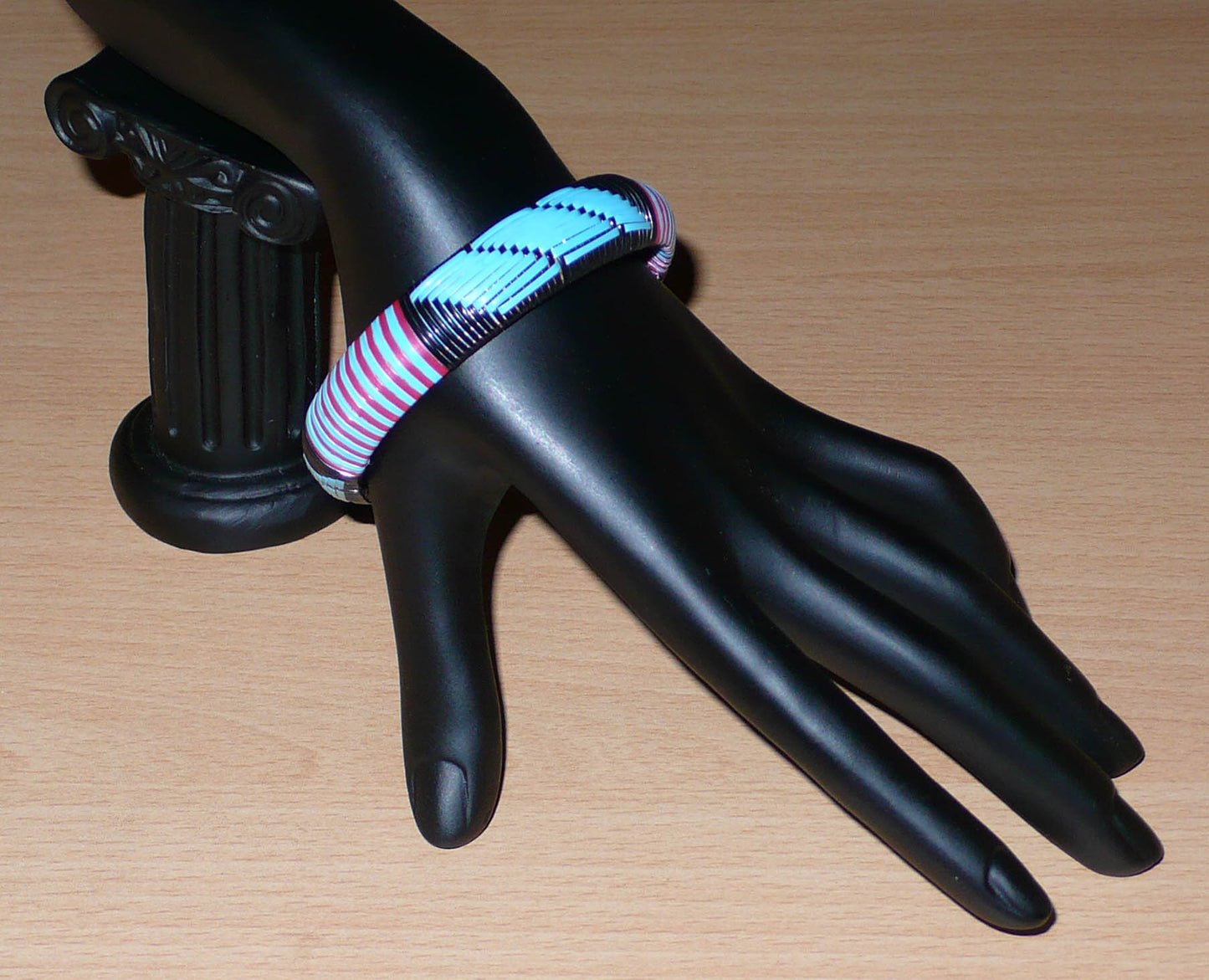 Bracelet africain tricolore à motifs tribaux tissés à partir de plastique recyclé bleu, noir et rose.