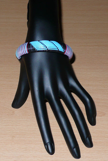 Bracelet africain tricolore à motifs tribaux tissés à partir de plastique recyclé bleu, noir et rose.