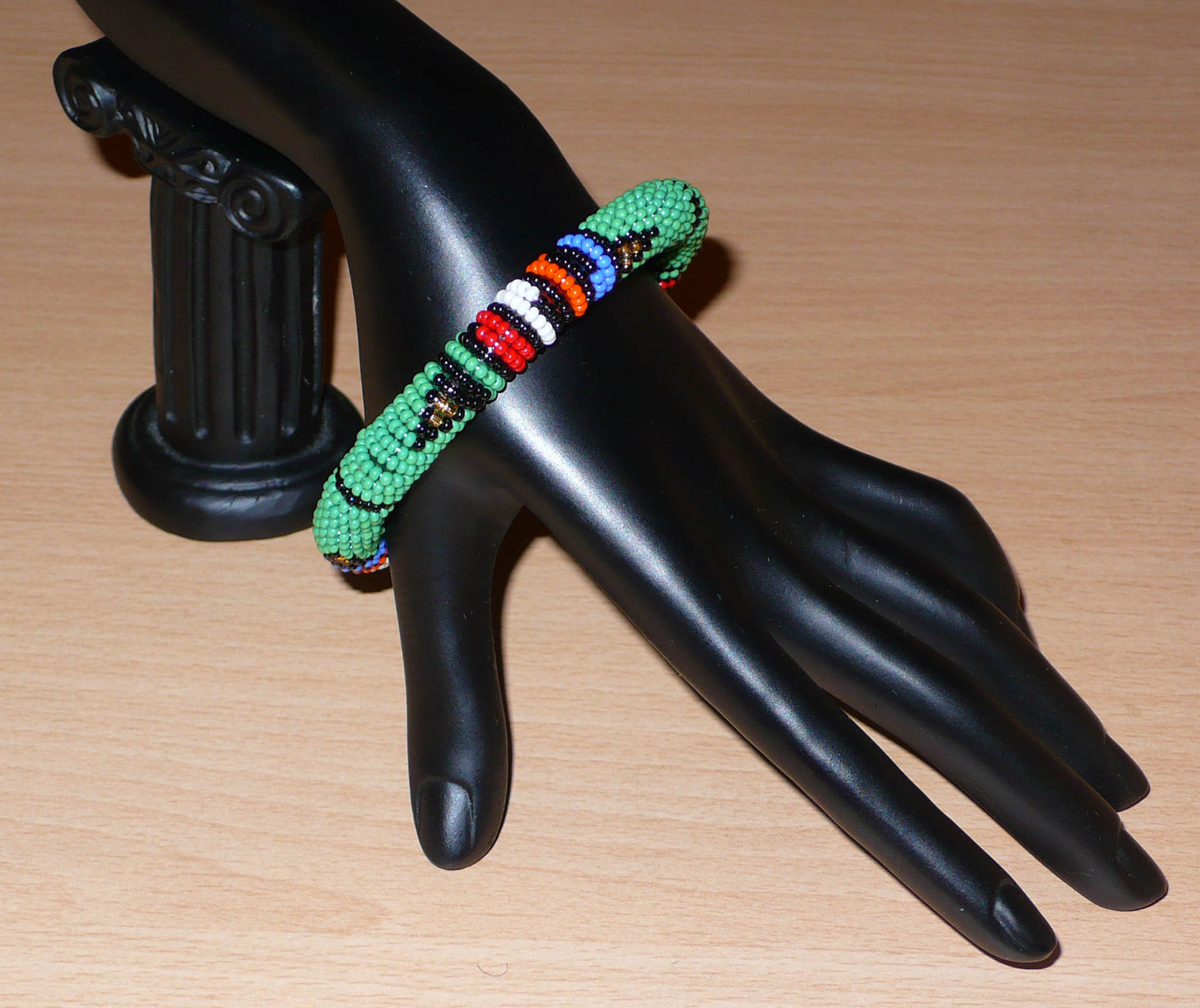 Bracelet africain tubulaire vert et multicolore à motifs ethniques traditionnels zoulous composé de perles de rocaille tissées.
