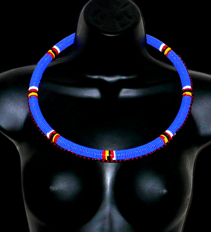 Collier africain Massai tubulaire composé de perles de rocaille principalement bleues, décoré de motifs ethniques perlés.