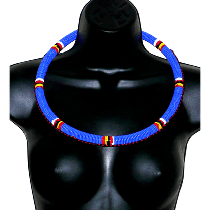 Collier africain Massai tubulaire composé de perles de rocaille principalement bleues, décoré de motifs ethniques perlés.
