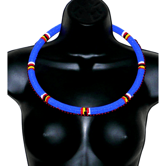 Collier africain Massai tubulaire composé de perles de rocaille principalement bleues, décoré de motifs ethniques perlés.