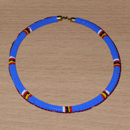 Collier africain Massai tubulaire composé de perles de rocaille principalement bleues, décoré de motifs ethniques perlés.